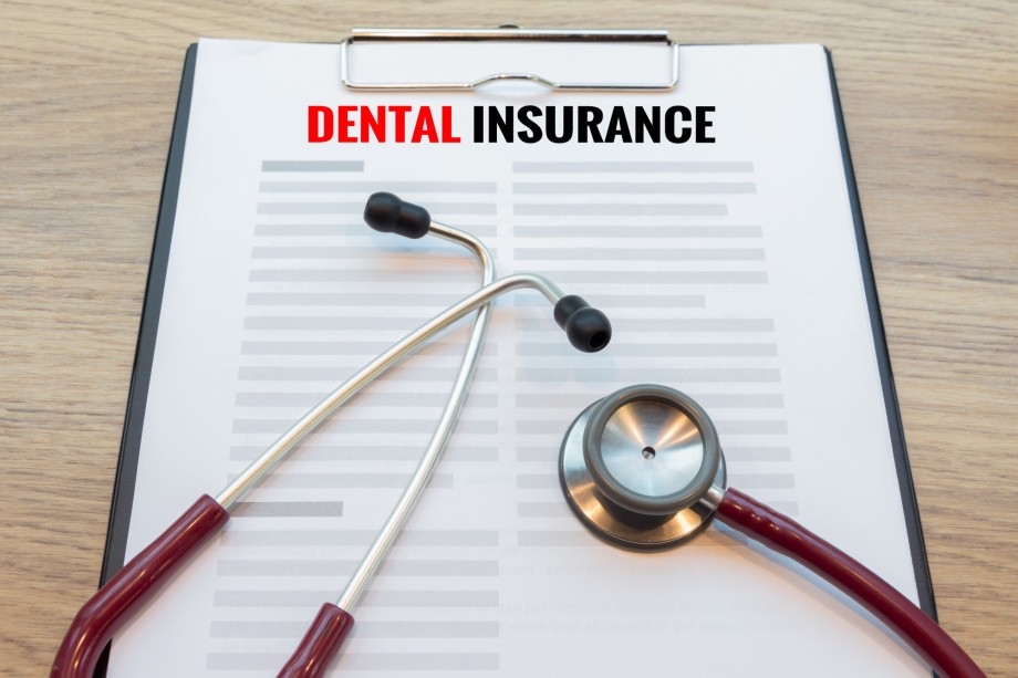 Dental insurance form with stethoscope lay down on wooden desk